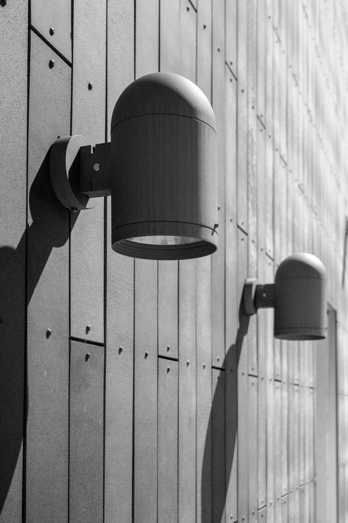Black and white photo of wall lamps on a metal building facade in Boise, Idaho.